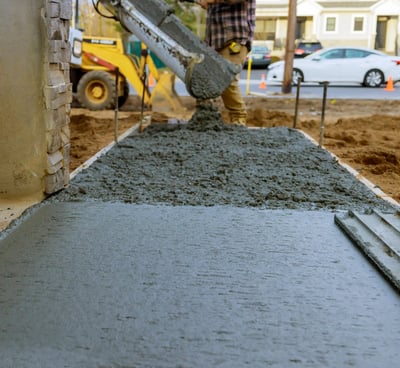 a man is pouring concrete into a concrete slab