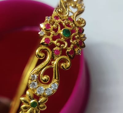 a gold bangle and a pink bracelet