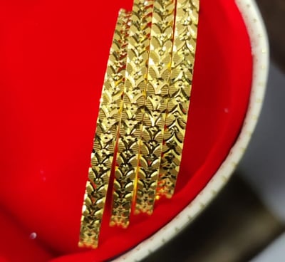 a red bowl with gold bangles