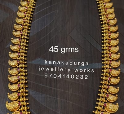 a gold necklace with a mango design