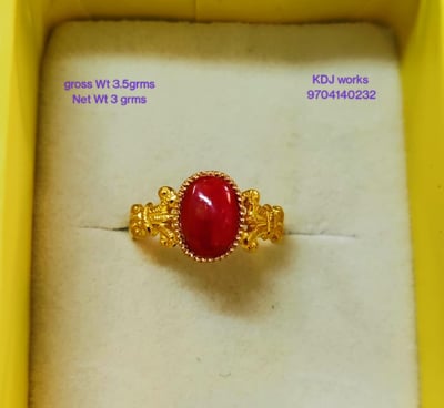 a ring with a red stone ring on top of a white box