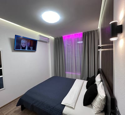 a bedroom with a television and a television