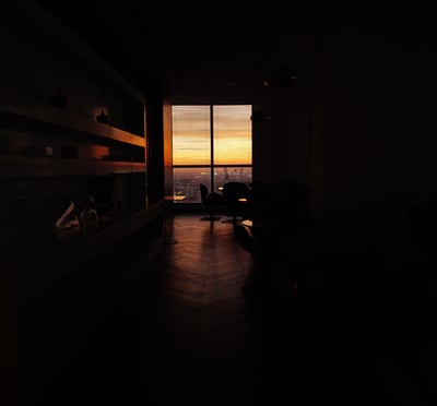 Dark interior with a sunset‑lit window in Phnom Penh, By ACAT Photos