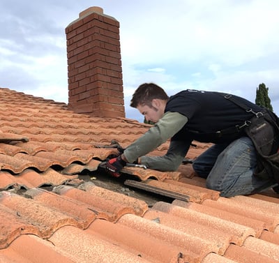 Working on a roof replacing tiles