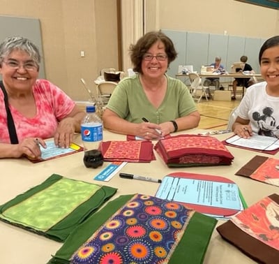 3 women tracing liners for Days for Girls at 3rd Thursday Humanitarian Day
