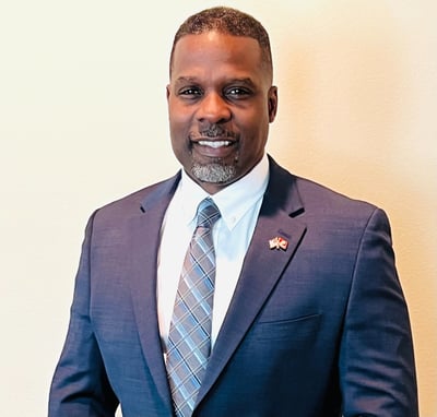 Dr. Marlon Ware professional headshot in blue suit with blue striped tie