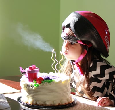 a young girl blowing out birthday candles