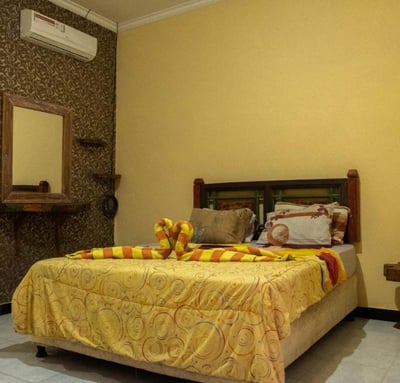 a bed with a yellow bedding and a mirror museum room at sunrise lodge and lounge