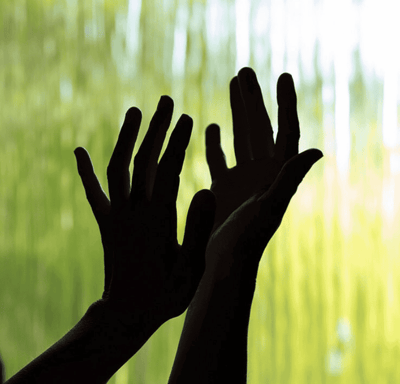 a person holding their hands up to a waterfall