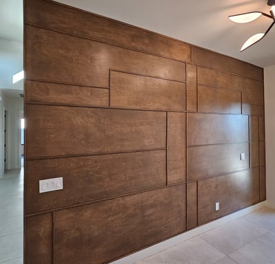 Modern accent wall with medium-tone wood trim, adding warmth and texture to a contemporary interior 