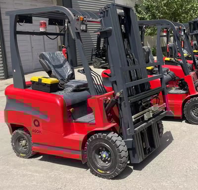 a row of forklift trucks parked in front of a building