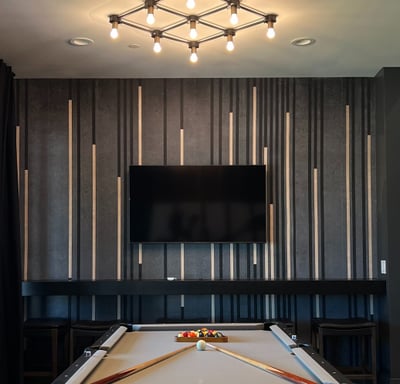 Modern accent wall featuring black, gold, and gray vertical wood slats against gray limewash