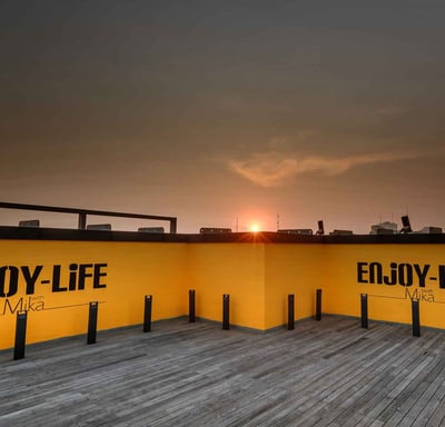 a sunset view of a city skyline with buildings and a sun setting