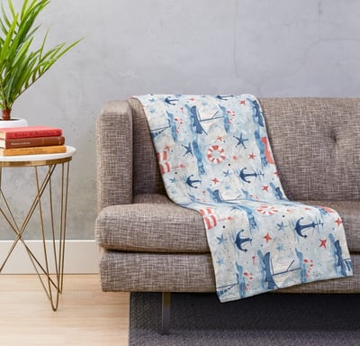 un canapé avec le plaid au motif marin