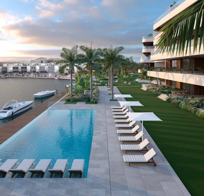 a pool with lounge chairs and a boat in the water