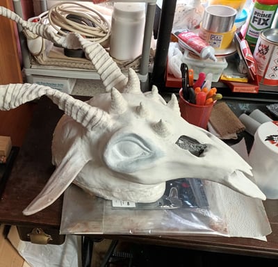 an unpainted full-head mask with horns and ears