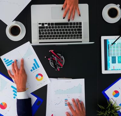 a group of people sitting around a table with printed charts