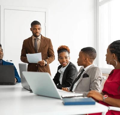 a man in a suit and tie is standing in front of a group of people