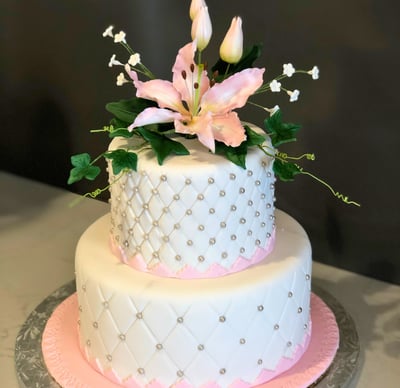 Elegant celebration cake decorated with refined details, available in chocolate or vanilla perfect for birthdays, weddings