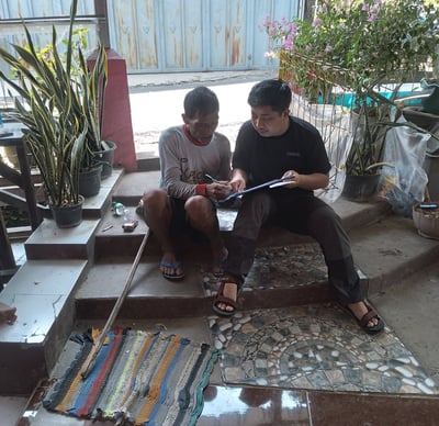 "Peneliti dan warga komunitas lokal berdiskusi bersama di ruang terbuka, merekam pengetahuan budaya 