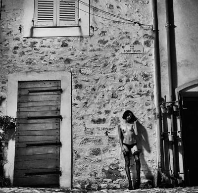 Photo noir et blanc d'une jeune presque nue dans la rue de nuit avec des croix sur les seins