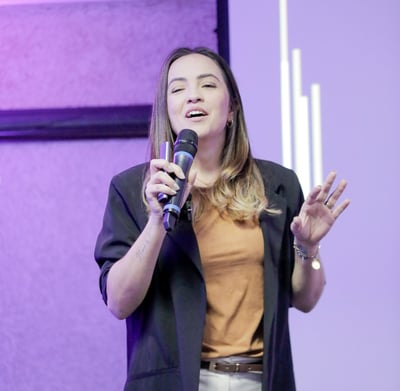 uma mulher em uma jaqueta preta e um microfone