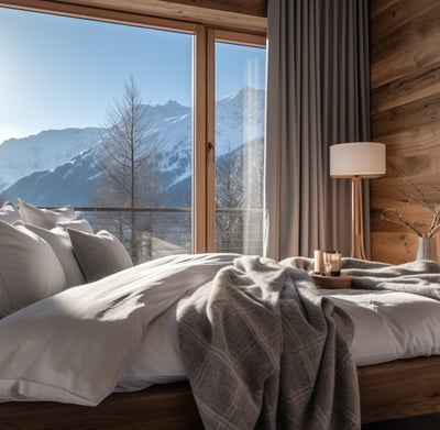 a view of the Alps visible through the large windows of a cabin bedroom