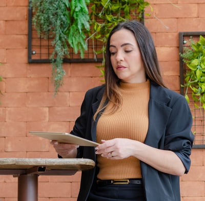 uma mulher de jaqueta preta e um tablet