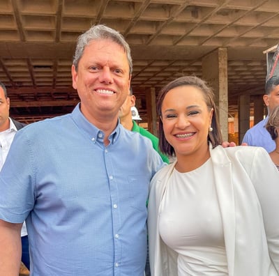 homem com camisa azul e mulher com blazer rosa sorrindo