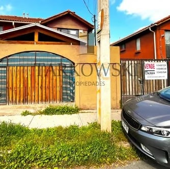 casa dos pisos color naranjo con puerta en forma de reja y cierre de cemento 