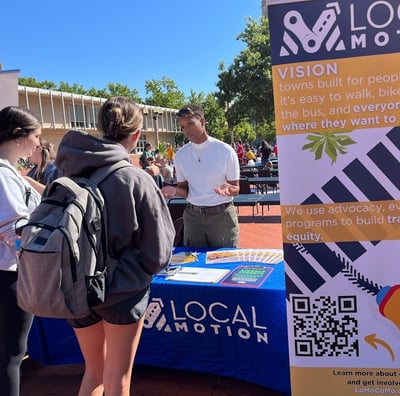 Photo of people visiting a Local Motion booth speaking with a staff member