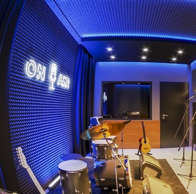 a man in a recording studio with a microphone and drums