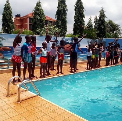 a group of people standing around a pool