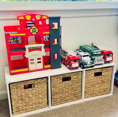an organized shelving unit with bins and toys