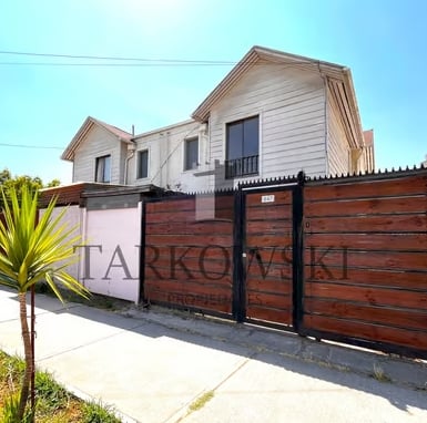 casa blanca de dos pisos con cuatro ventanas y portón café con palmera al frente a la venta