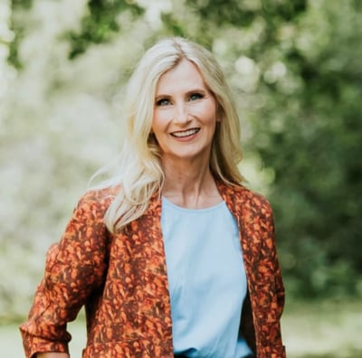 Portrait photo of Tina Rush founder of Outfluential NZ. Blonde woman smiling in outdoor setting. 