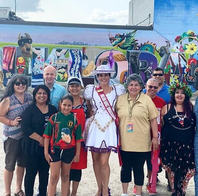 a group of people standing in front of a mural