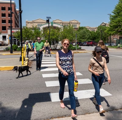 People walking across a crosswalk toward the camera