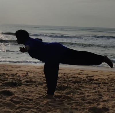 a person doing yoga on a beach