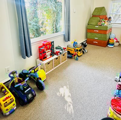 an organized playroom with a window and toys