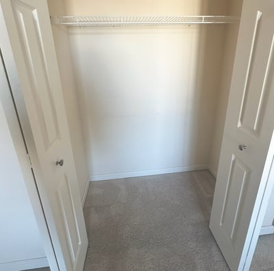 an empty closet with a closet door open and a closet with a shelf