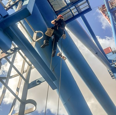 a man on a rope rope with a rope tied to a metal structure