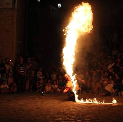 momento dello spettacolo di fuoco firestorm con la frusta infuocata e l'arte dello sputafuoco