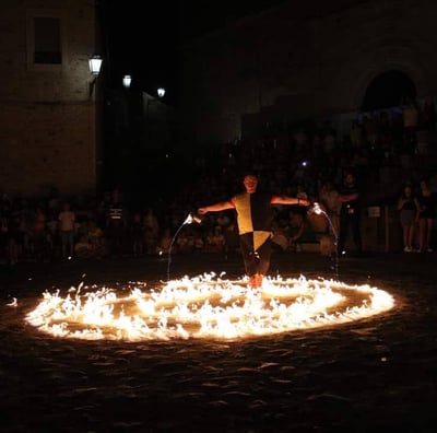 artista di strada durante il numero della colata di fuoco immerso nelle fiamme sul pavimento