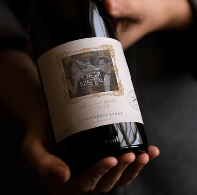 wine label on a dark bottle, label has an illiustrstion of picture frame and a photo design