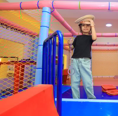 A baby girl standing on slide