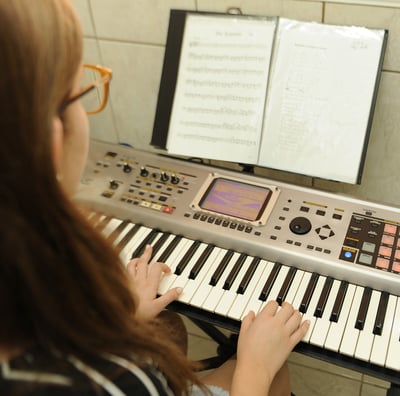 aluna estudando partitura com metodo da escola toque talento