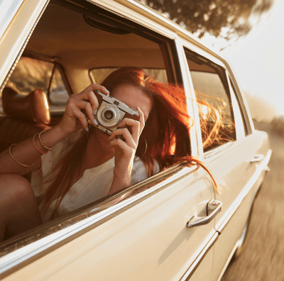 a woman taking a picture of herself in a car