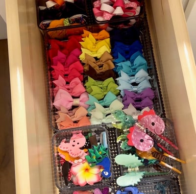 an organized drawer full of colorful hair clips