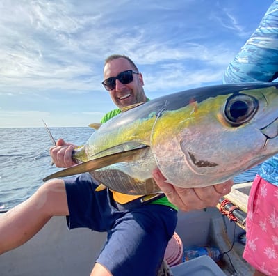 A man holding a fish in his hands during a Zanzibar fishing charter, perfect for Zanzibar fishing